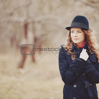 Spring portrait of red hair girl in hat and coat.