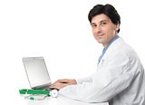 Doctor sitting at his desk with laptop computer