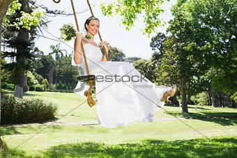 Young bride swinging in garden