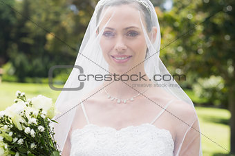 Closeup of bride wearing veil in garden
