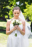 Bride holding flower bouquet in garden