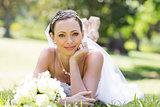 Young bride lying on grass in park