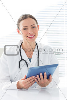 Confident female doctor holding digital tablet