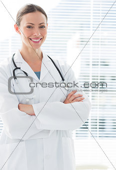 Confident female doctor standing arms crossed