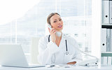 Confident doctor using telephone at desk