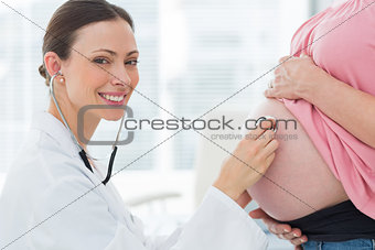 Portrait of doctor checking pregnant woman