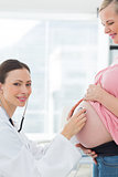 Beautiful doctor examinng pregnant woman