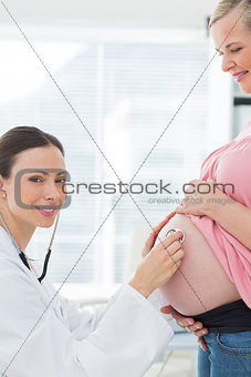 Beautiful doctor examinng pregnant woman