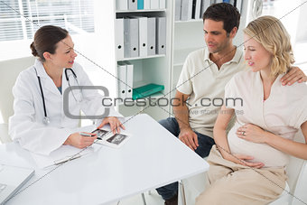 Gynaecologist explaining reports to expectant couple