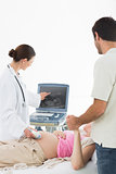 Doctor showing ultrasound screen to couple