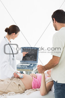 Doctor showing ultrasound screen to couple