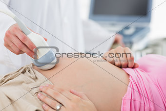 Doctor doing ultrasound on pregnant woman