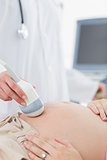 Doctor performing ultrasound on pregnant woman