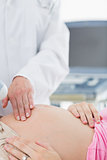 Doctor touching belly of pregnant woman
