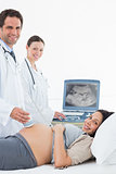 Doctors performing ultrasound on pregnant woman