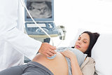 Male doctor performing ultrasound on pregnant woman