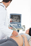 Doctor showing ultrasound results to pregnant woman