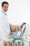 Doctor performing ultrasound on expectant woman