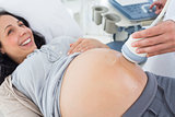 Smiling pregnant woman receiving ultrasound