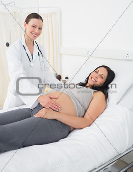 Happy female doctor with pregnant woman