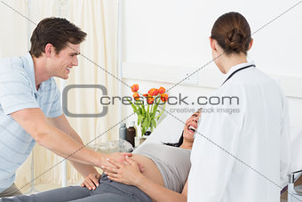 Doctor with happy expectant couple