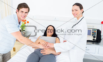 Happy doctor and expectant couple