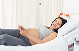 Happy pregnant woman lying in bed
