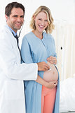 Happy pregnant woman with male doctor
