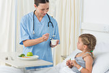 Doctor feeding meal to sick girl