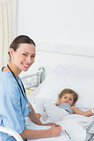 Doctor with clipboard attending sick girl