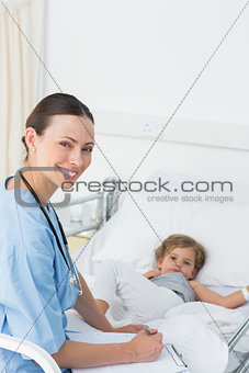 Doctor with clipboard attending sick girl