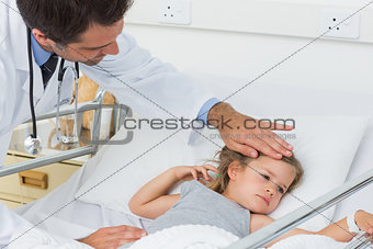 Doctor checking temperature of sick girl