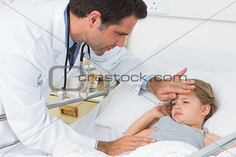 Doctor examining temperature of ill girl