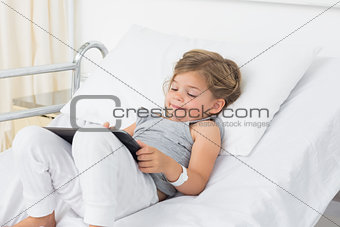 Little sick girl using digital tablet