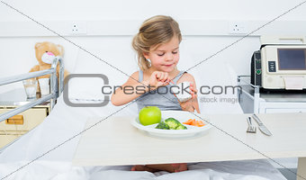 Ill girl eating healthy food in hospital