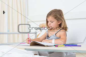 Girl coloring book in hospital