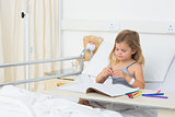 Girl coloring picture book in hospital