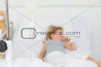 IV drip with sick girl in hospital bed