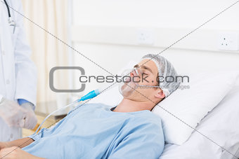 Male doctor adjusting oxygen mask on patient