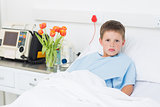 Boy reclining in hospital bed