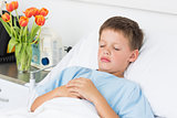 Sick boy sleeping in hospital bed