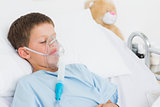 Boy with oxygen mask in bed