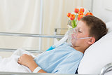 Sick boy wearing oxygen mask in hospital