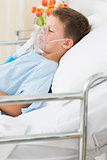 Boy wearing oxygen mask in bed