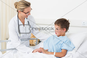 Doctor examining sick boy in hospital