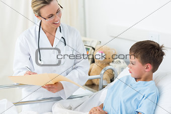 Doctor examining report of sick boy