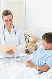 Doctor reading report of sick boy