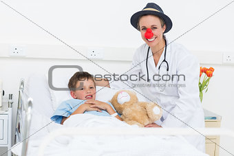 Doctor in clown costume with boy in hospital