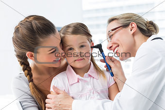 Girl being examined by doctor with otoscope