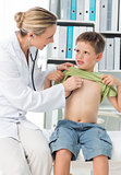 Pediatrician examining boy with stethoscope